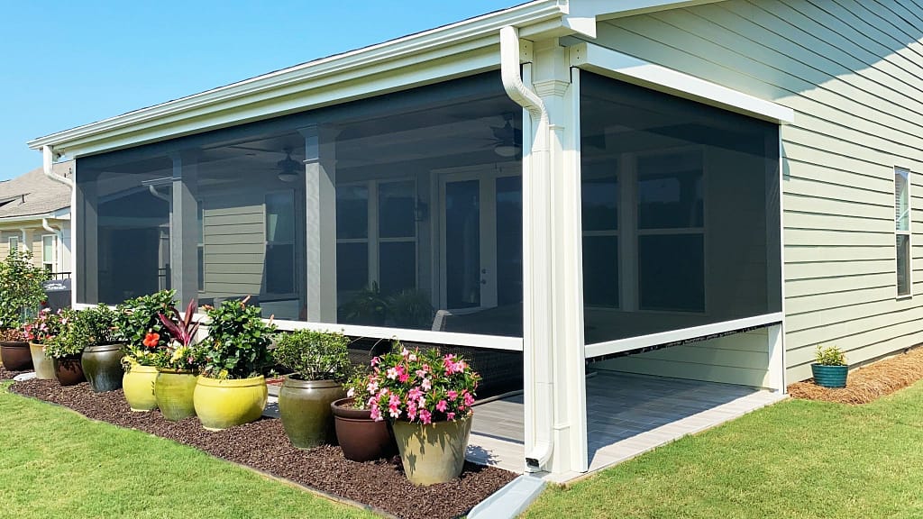 A patio screened-in on three sides by motorized retractable screens, creating a more comfortable outdoor seating area.