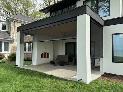 A patio with multiple screened-in sides, creating a more comfortable outdoor seating area.