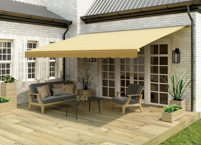A bright yellow Sunsetter retractable awning provides shade for a beautiful and well made wooden deck.